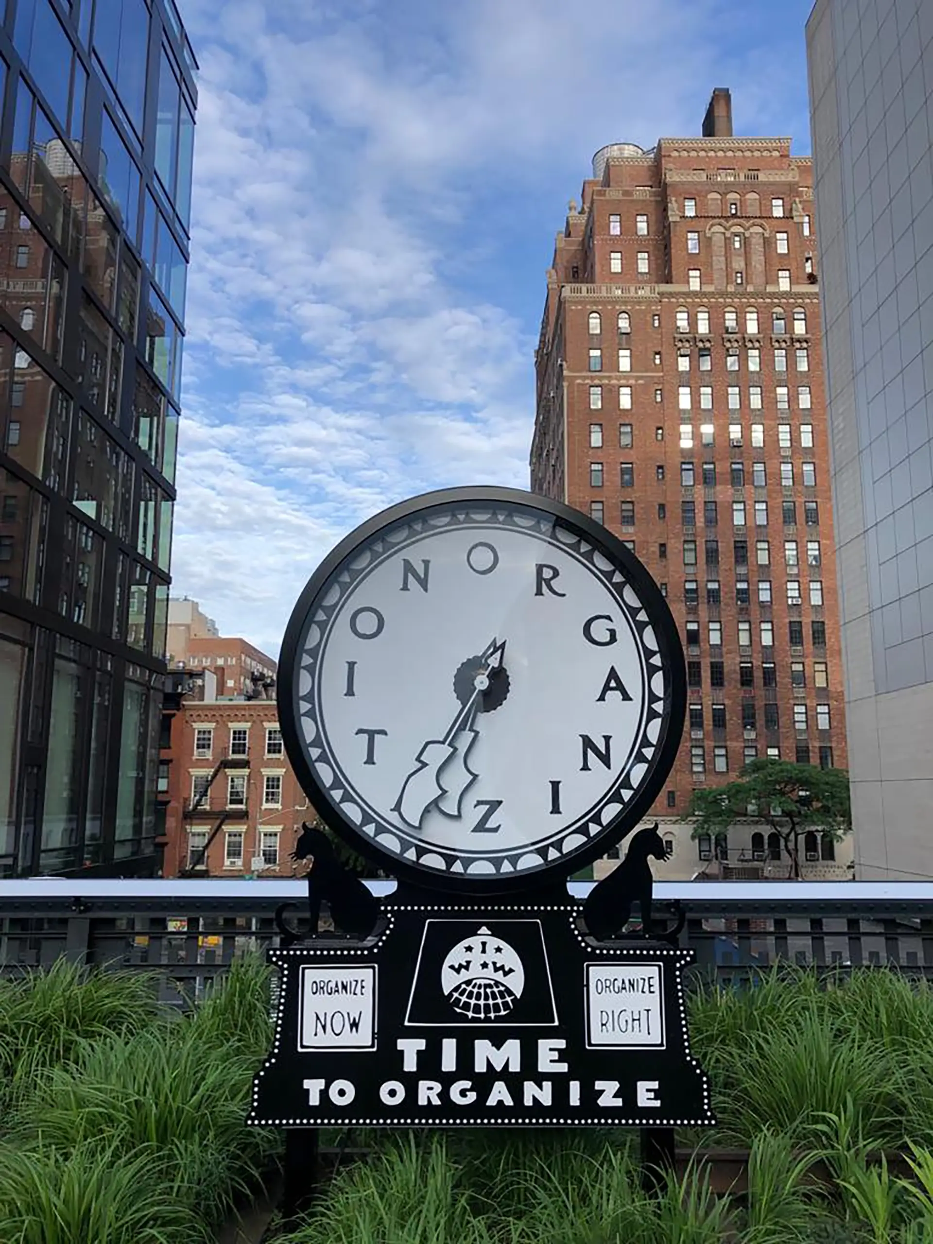 Kunstinstallation mit großer Uhr und Schriftzug Time to Organize zwischen Gebäuden in New York