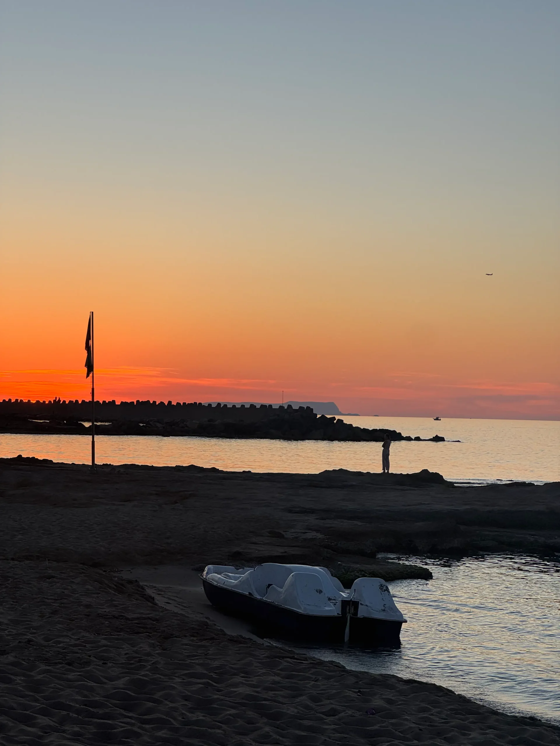Tretboot am Strand von Malia während eines orangefarbenen Sonnenuntergangs auf Kreta
