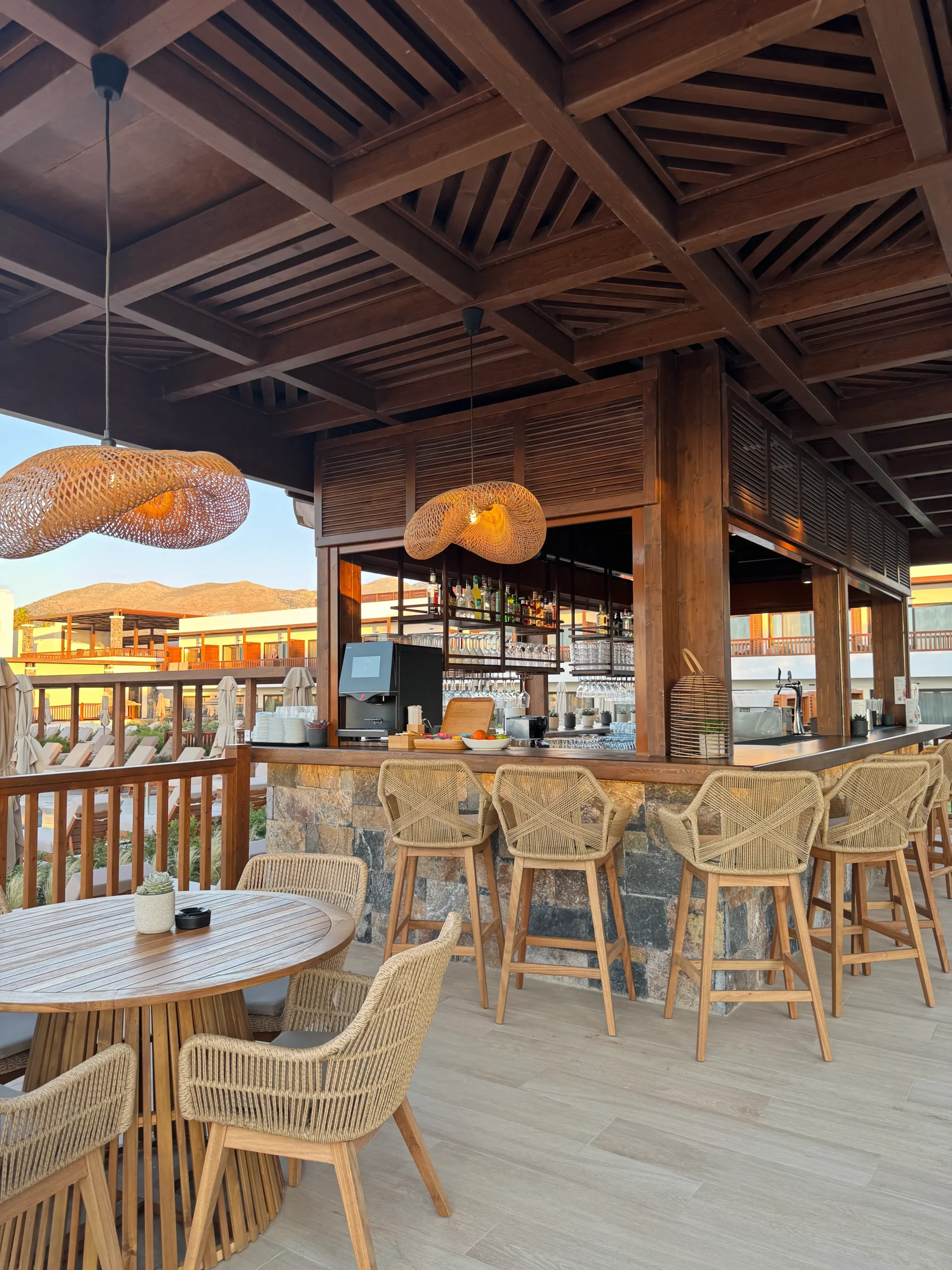 Offene Strandbar des allsun Hotel Carolina Sun Beach mit Holzmöbeln und geflochtenen Lampen