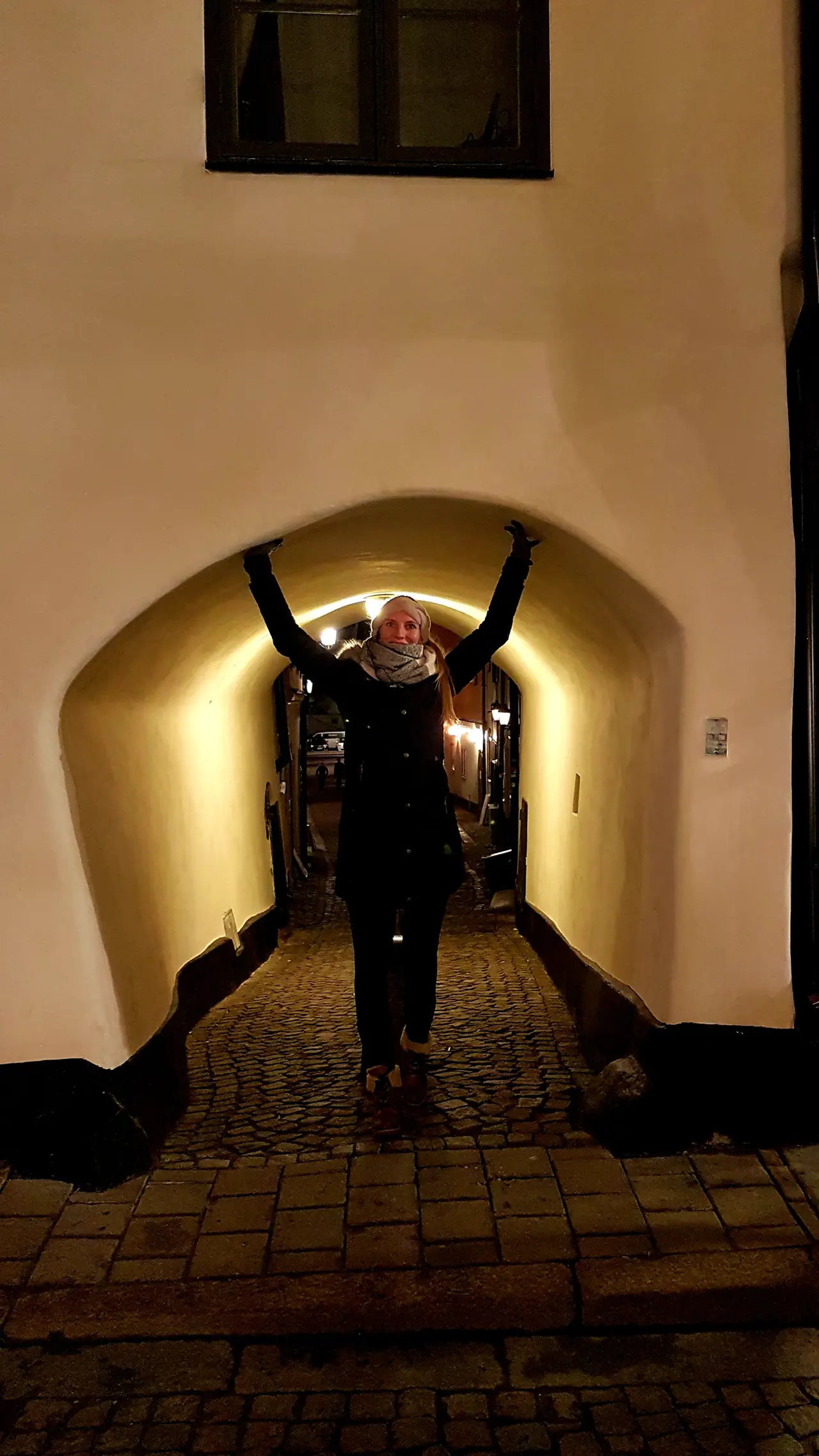 Verwinkelte Gassen in Gamla Stan entdecken Person unter einem niedrigen historischen Torbogen in der Stockholmer Altstadt Gamla Stan