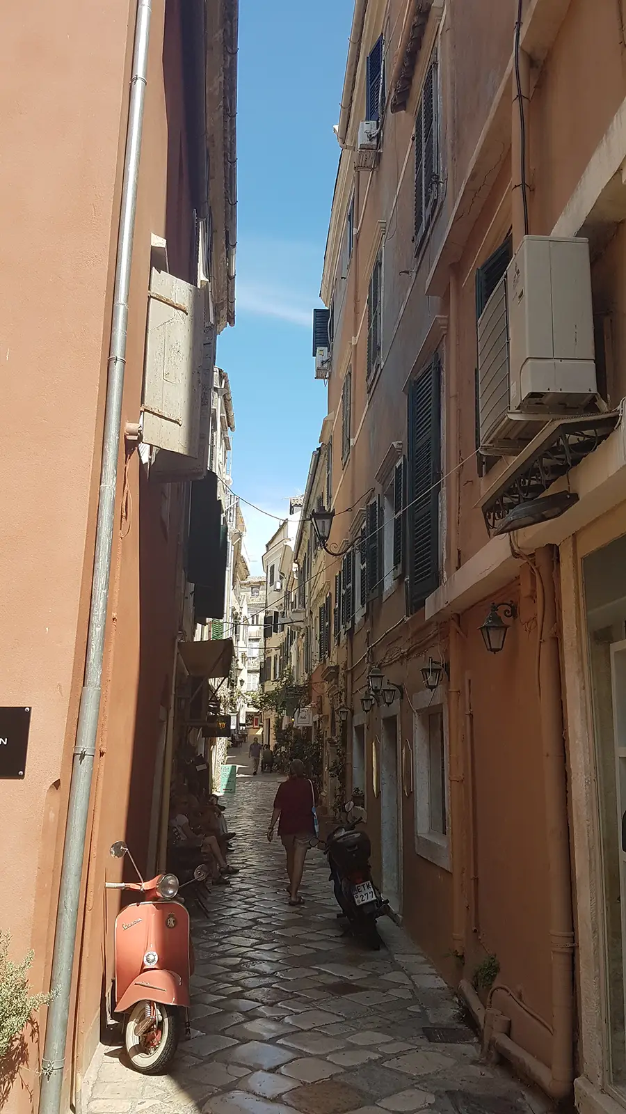 Schmale mediterrane Altstadtgasse mit Vespa während des Landgangs auf Korfu